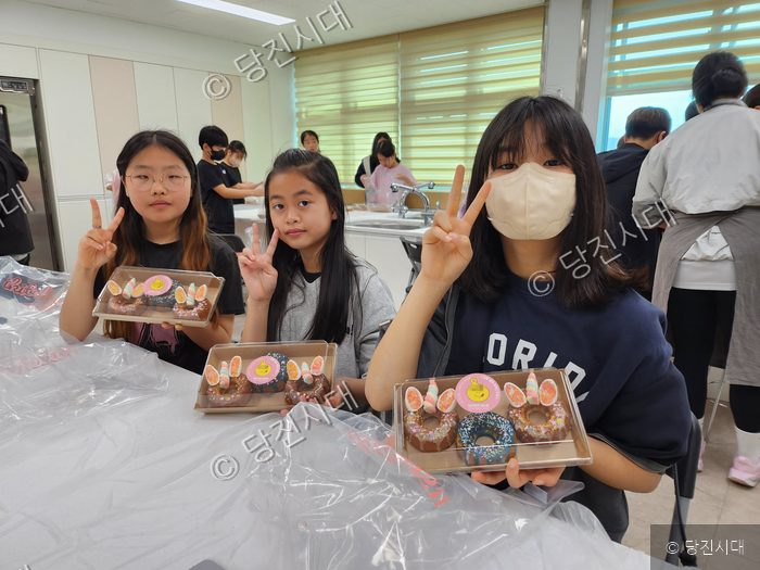 송산초등학교 학생들이 학교로 찾아오는 체험학습 프로그램에 참여해 직접 만든 도넛을 보여주고 있다.