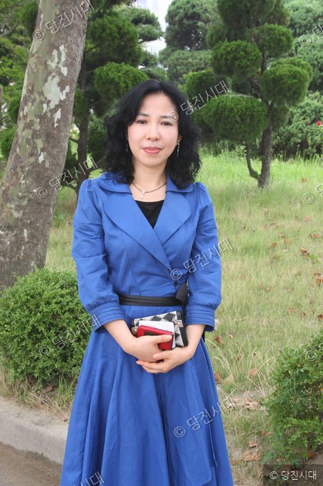 김미향 시인이 야외 정원에서 포즈를 취하고 있다.