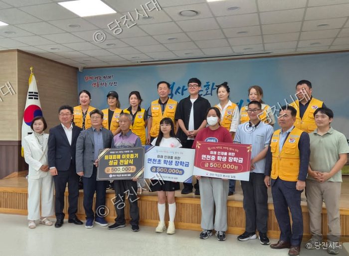 당진 면천면 적십자봉사회 회원들이 지역 사회에 성금과 장학금을 전달하고 기념 촬영을 하고 있다.