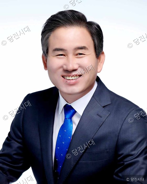 김봉균 의원이 정장 차림으로 미소 지으며 카메라를 바라보고 있다.