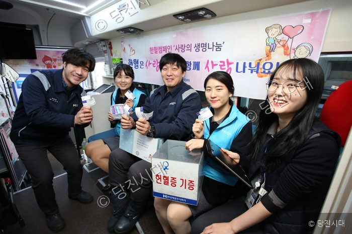 현대제철 임직원들이 헌혈 캠페인 버스 안에서 헌혈증을 기증하고 있다.