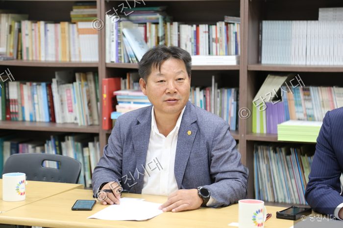 회의 테이블에 앉아 서류를 보며 이야기하고 있다.
