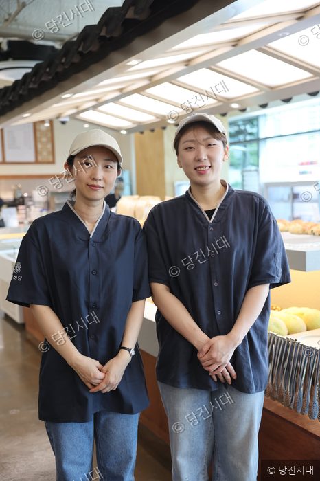 밀화당 당진시청점의 직원 두 명이 매장에서 미소 짓고 있다.