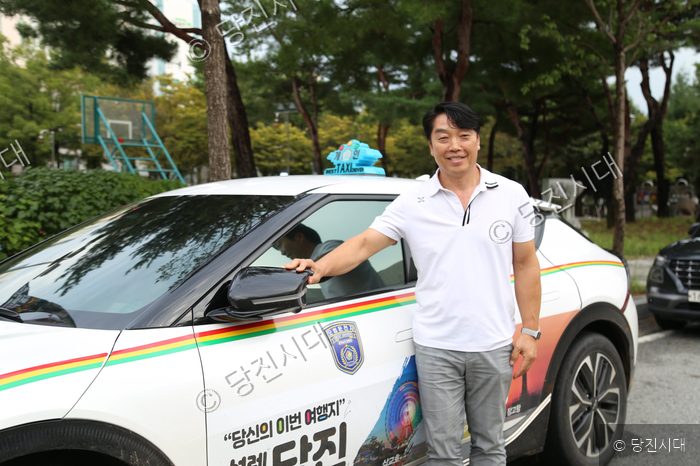 노종호 씨가 자신이 운전하는 택시 옆에서 미소를 짓고 있다.