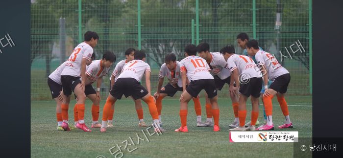 신평중학교 축구부 선수들이 운동장에 모여 파이팅을 외치고 있다.