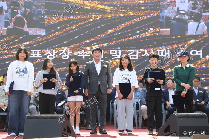 석문면체육회 관계자들이 무대 위에서 표창장과 감사패를 수여하고 있다.