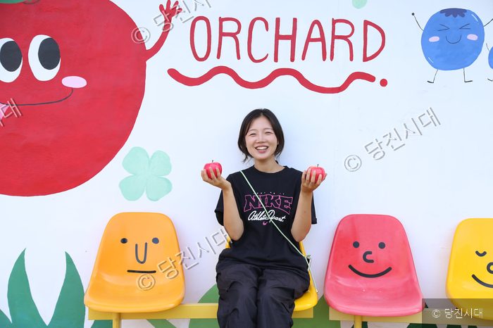 성은영 대표가 버미오차드 사과 농장에서 사과를 들고 포즈를 취하고 있다.
