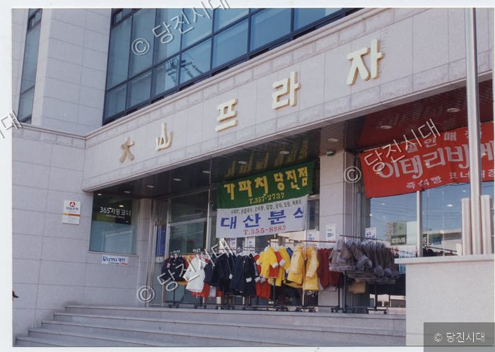 당진의 한 건물 상가 앞 계단에 의류 판매대가 놓여 있다.