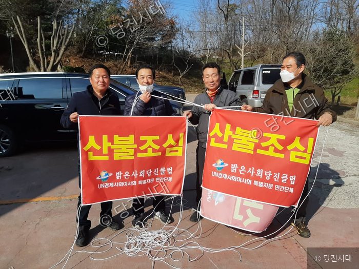 당진 지역 시민들이 산불 예방 홍보 현수막을 들고 서 있다.