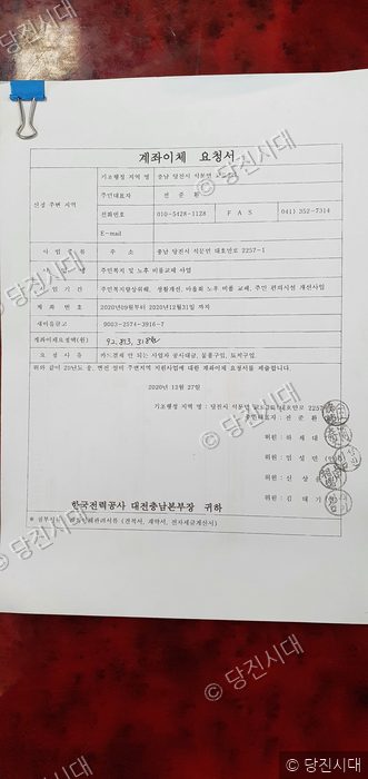 교로3리의 주민복지 및 노후 비품교체 사업 계좌이체 요청서 문서가 놓여 있다.