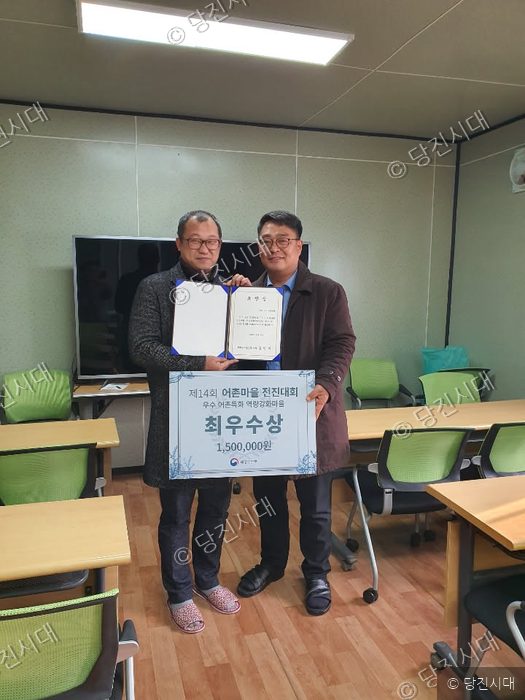 어촌계 씨 등이 어촌마을 전진대회 최우수상 상장과 판넬을 들고 기념 촬영을 하고 있다.