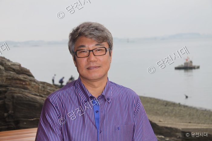 김창래 대표가 바닷가 배경으로 포즈를 취하고 있다.