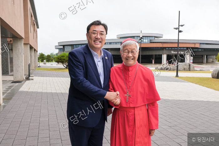 김기재 당진시장과 유흥식 추기경이 솔뫼성지에서 악수하고 있다.
