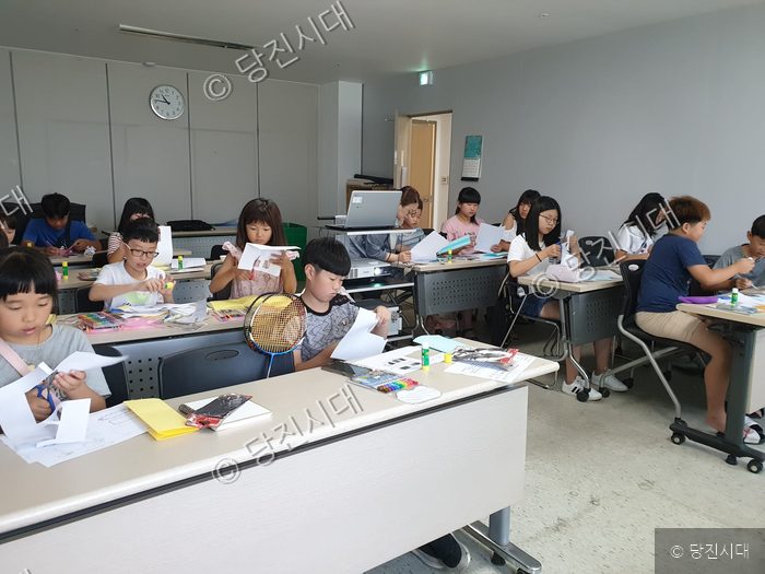 어린이들이 복지관 교실에 모여 종이접기 등 방학 프로그램을 하고 있다.