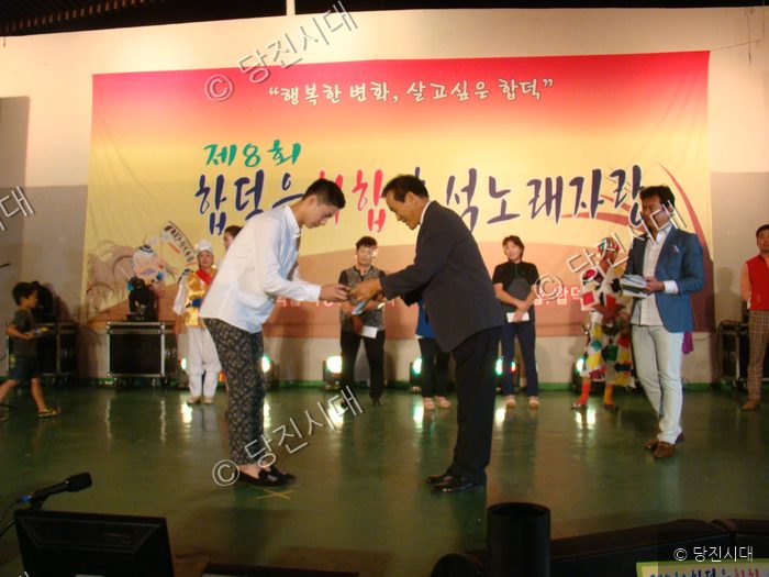 합덕읍 주민이 무대에서 상을 받고 있다.