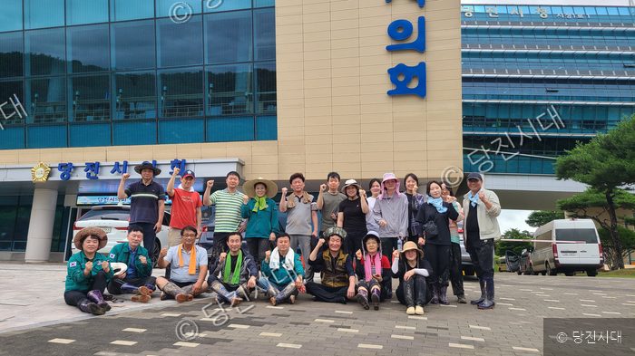 당진시의회 의원들과 자원봉사자들이 수해복구 작업 후 기념촬영을 하고 있다.
