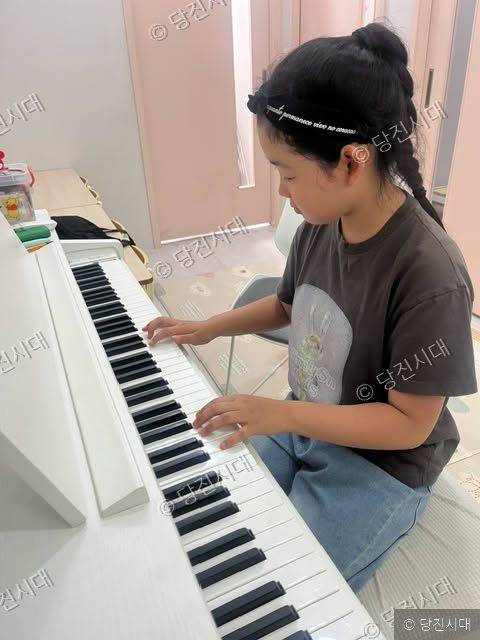 오슬아 원장이 피아노 교습소에서 피아노를 치고 있다.
