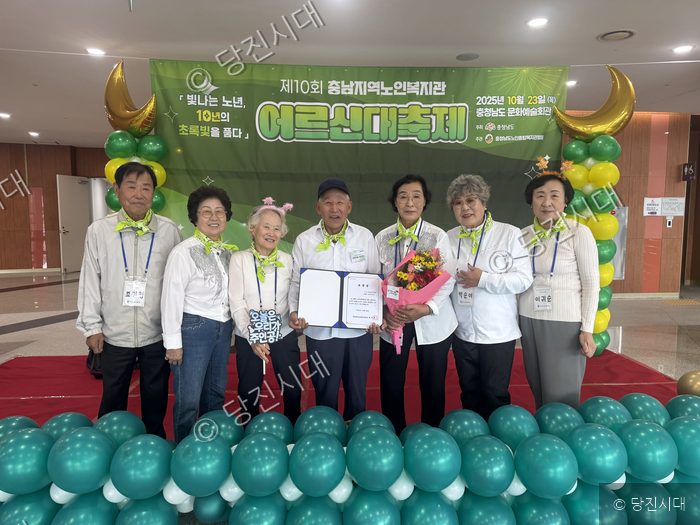 당진시남부노인복지관 은빛마술봉사단원들이 표창장을 받고 기념촬영을 하고 있다.