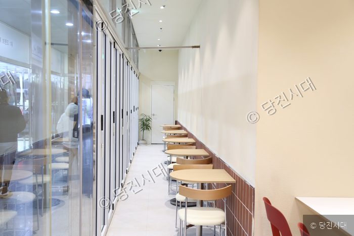러버스커피 내부의 깔끔한 테이블과 의자들이 놓여 있다.