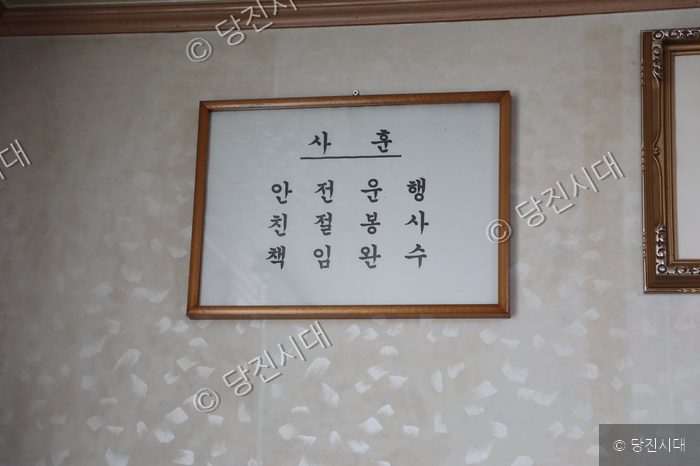 대영택시 사무실 벽면에 안전운행과 친절봉사를 다짐하는 사훈 액자가 걸려 있다.