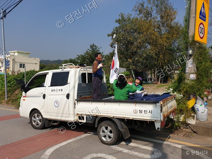 당진시 공무원들이 거리에서 태극기를 정비하고 있다.