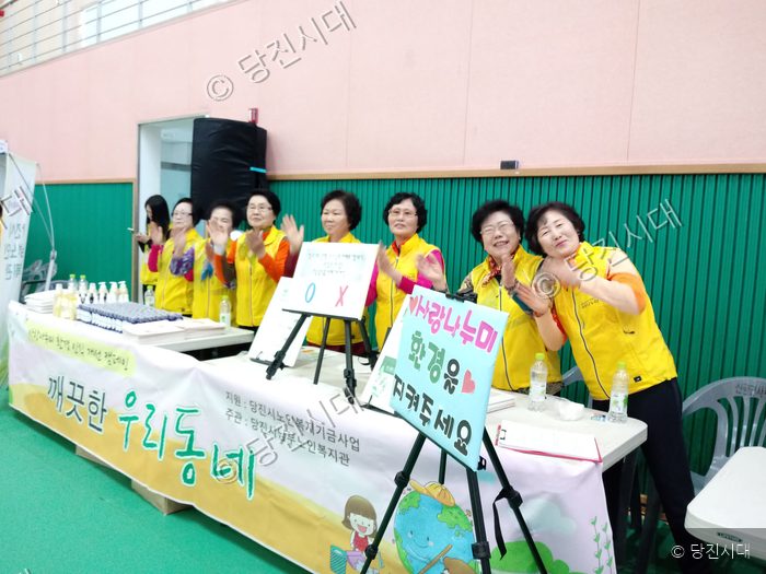 노인복지관 관계자들이 깨끗한 우리동네 캠페인 부스에서 기념촬영을 하고 있다.