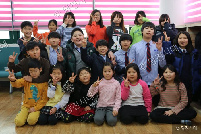 석문지역아동센터 아동들이 브이 포즈를 취하며 밝게 웃고 있다.