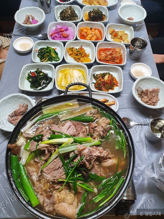 식탁 위에 능이버섯 백숙과 여러 가지 반찬들이 차려져 있다.