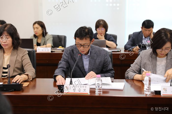 참석자들이 회의실에 모여 자료를 검토하고 있다.