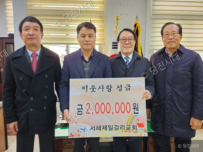 네 명의 남성이 서해제일감리교회 이웃사랑 성금을 전달하고 있다.