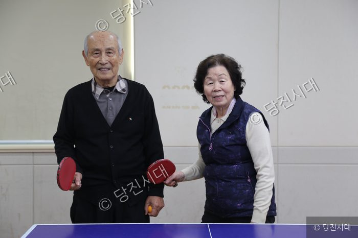 탁구 채를 든 류지환, 이순희 부부가 기념 촬영을 하고 있다.