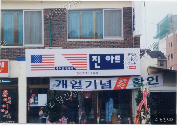 당진의 한 의류 매장 간판과 개업 기념 할인 현수막이 걸려 있다.