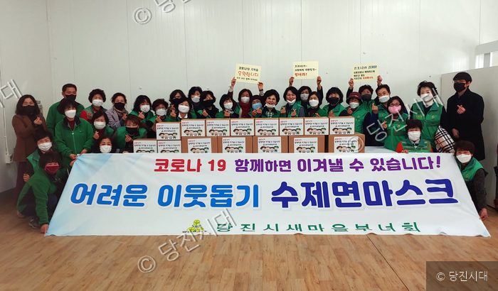 당진시 새마을부녀회 회원들이 취약계층을 위한 수제 면마스크를 전달하며 기념 촬영을 하고 있다.