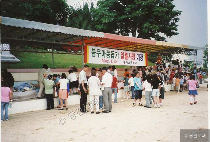 송악초등학교 학생들이 불우아동돕기 알뜰시장을 열어 물건을 살펴보고 있다.
