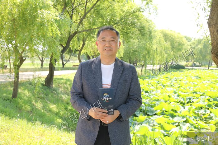 홍성록 씨가 합덕연꽃축제 홍보물을 들고 서 있다.