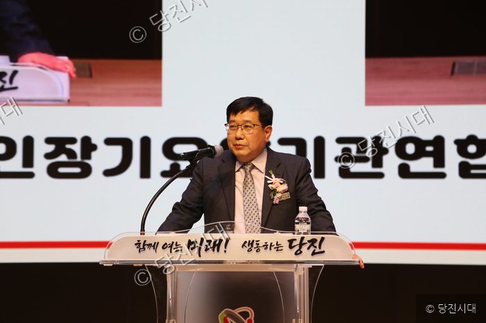 박종육 회장이 연단에 서서 마이크를 잡고 발표를 하고 있다.