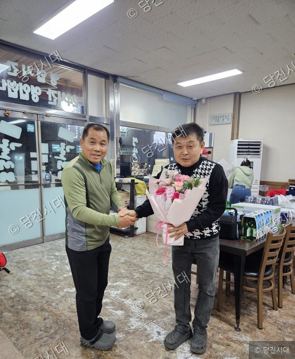 당진산악회 회장 취임식에서 회원들이 축하 꽃다발을 전달하고 있다.