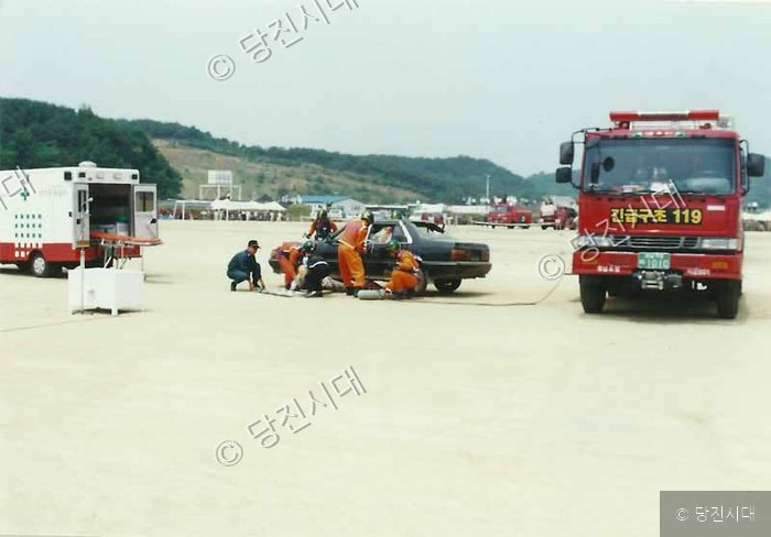 소방대원들이 사고 차량 주변에서 구조 훈련을 하고 있다.