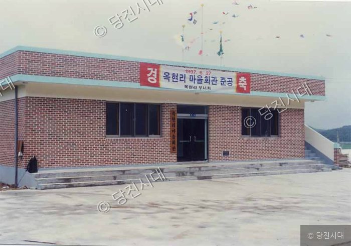 마을회관 앞에 완공을 축하하는 현수막이 걸려 있다.