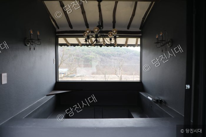 감성스테이 산아래 펜션의 검은색 인테리어로 꾸며진 실내 욕조 공간을 보여주고 있다.