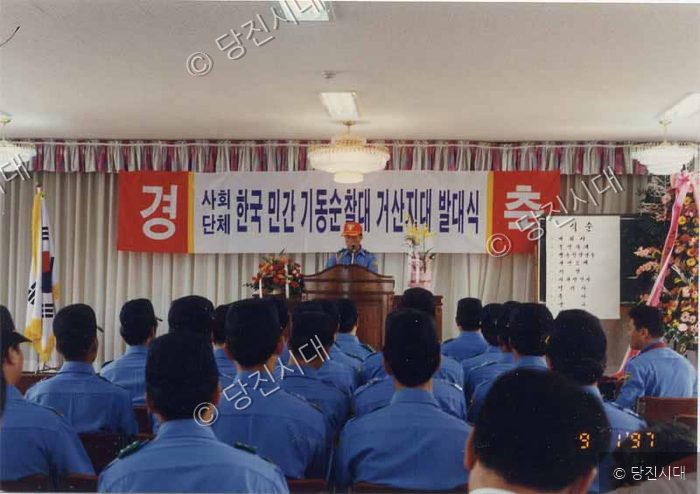 사람들이 모여 한국 민간 기동순찰대 거산지대 발대식을 개최하고 있다.