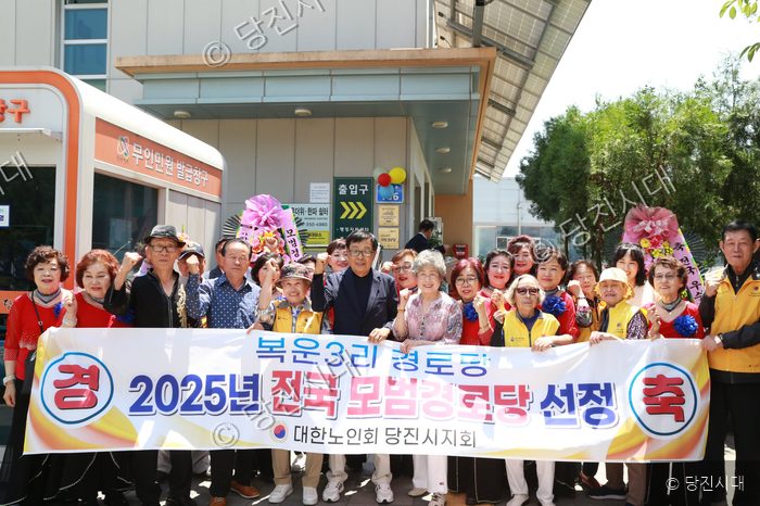 주민들과 관계자들이 복운3리 경로당의 전국 모범경로당 선정을 기념하며 포즈를 취하고 있다.